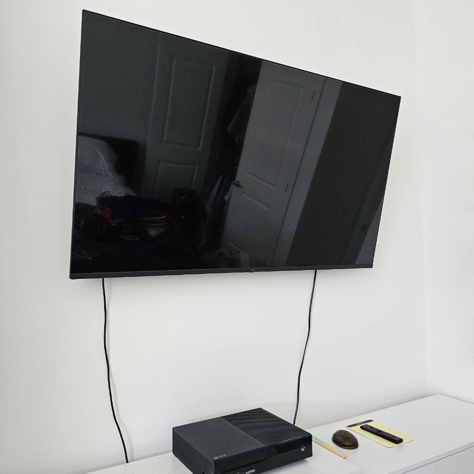 Wall-mounted flat screen TV with home theater soundbar